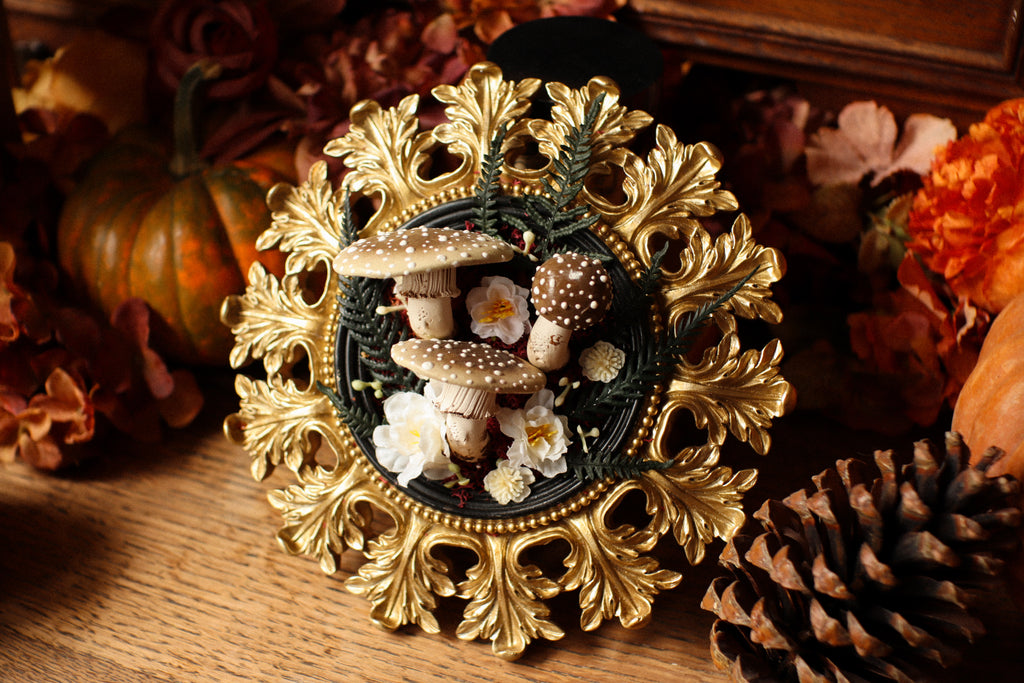 Cadre soleil style baroque noir et doré aux amanites et fleurs crèmes