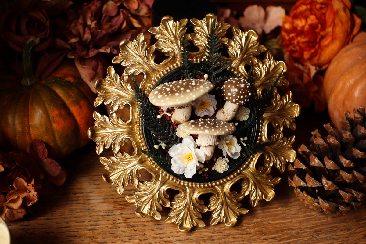 Cadre soleil style baroque noir et doré aux amanites et fleurs crèmes