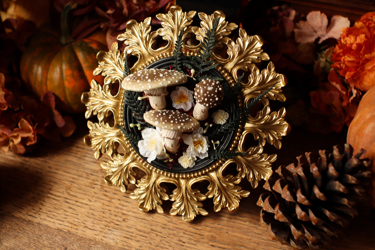 Cadre soleil style baroque noir et doré aux amanites et fleurs crèmes